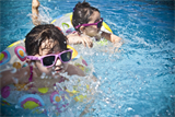 Kinder mit Schwimmreifen im Wasser